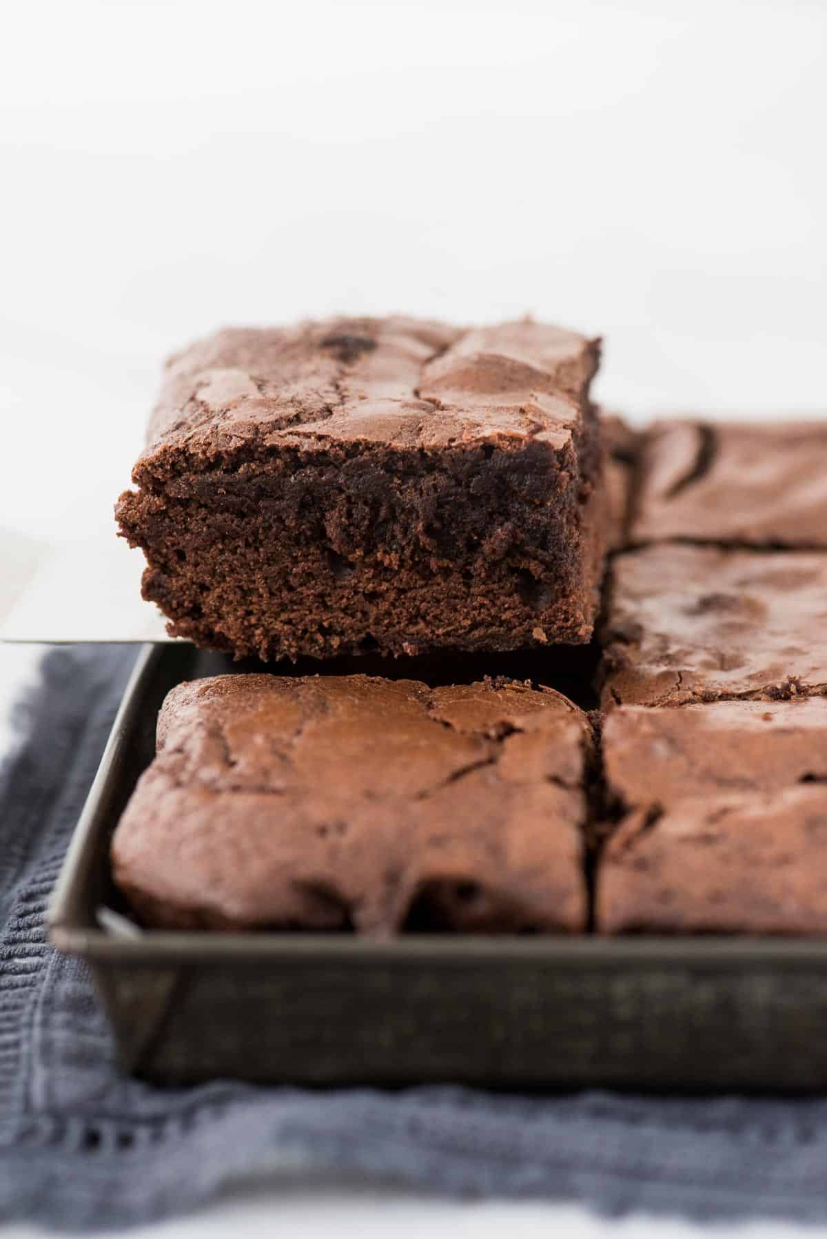 brownie being removed from pan on metal spatula