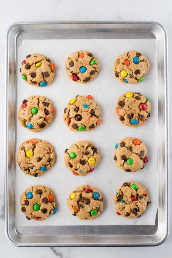 12 monster cookies on baking sheet with parchment paper