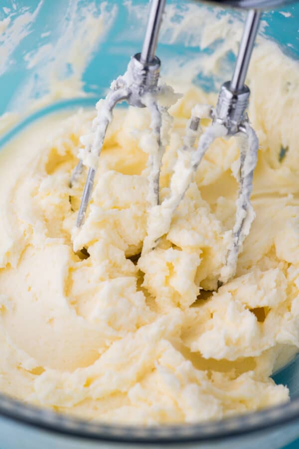 lemon frosting in clear mixing bowl with electric mixer
