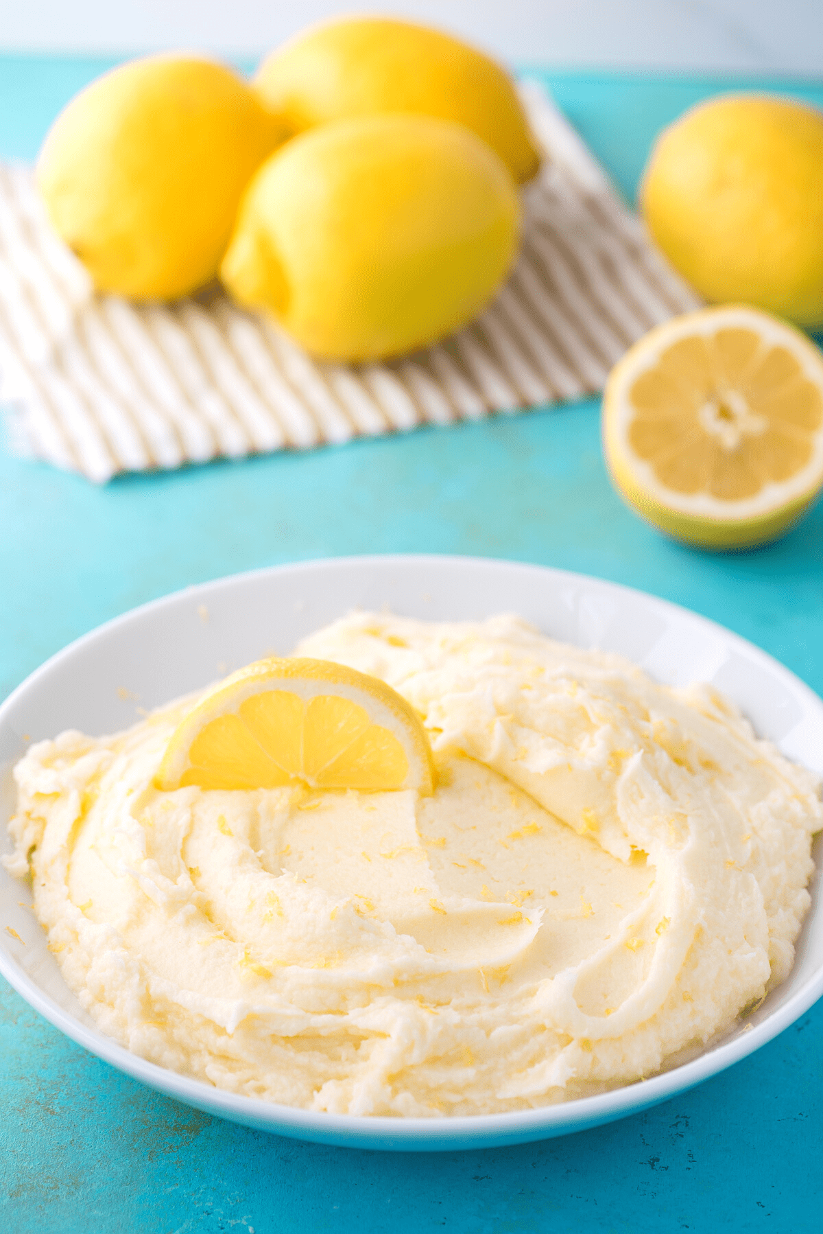 lemon frosting in white bowl on teal background