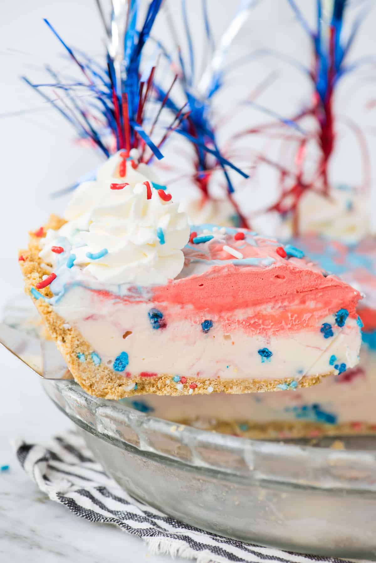slice of 4th of july red, white and blue ice cream pie on metal spatula being removed from pie pan