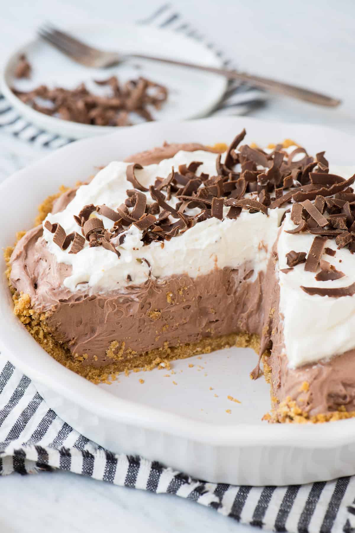 chocolate pudding pie with slice removed from pie pan on white background