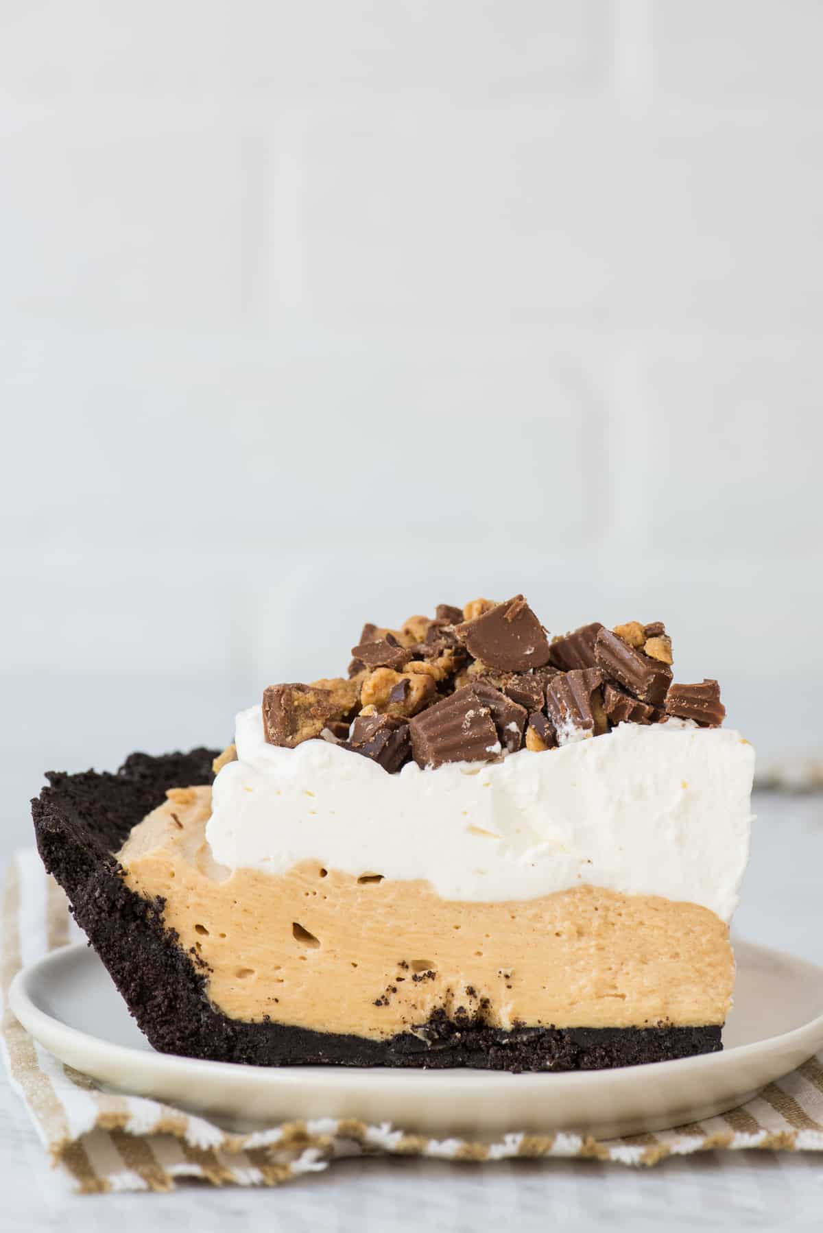 slice of peanut butter pie on white plate with white background