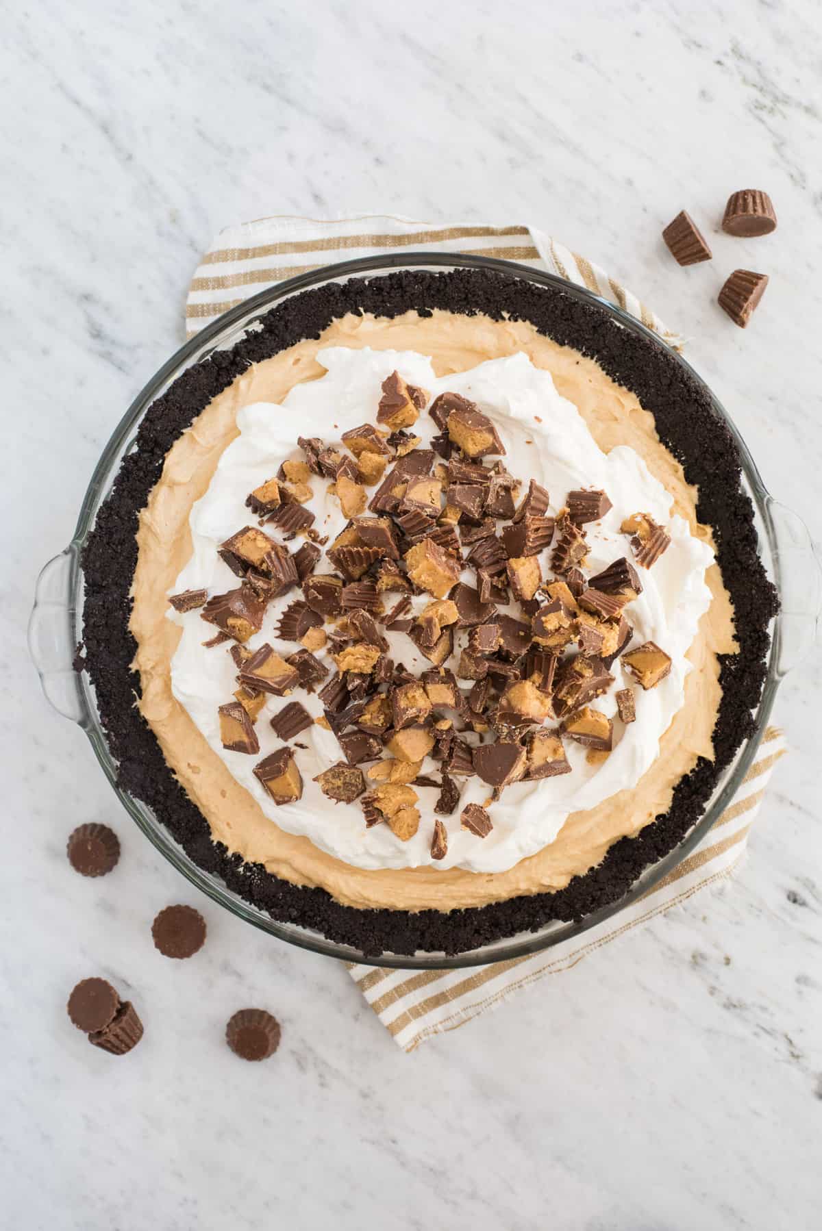 whole peanut butter pie in pie pan on marble background