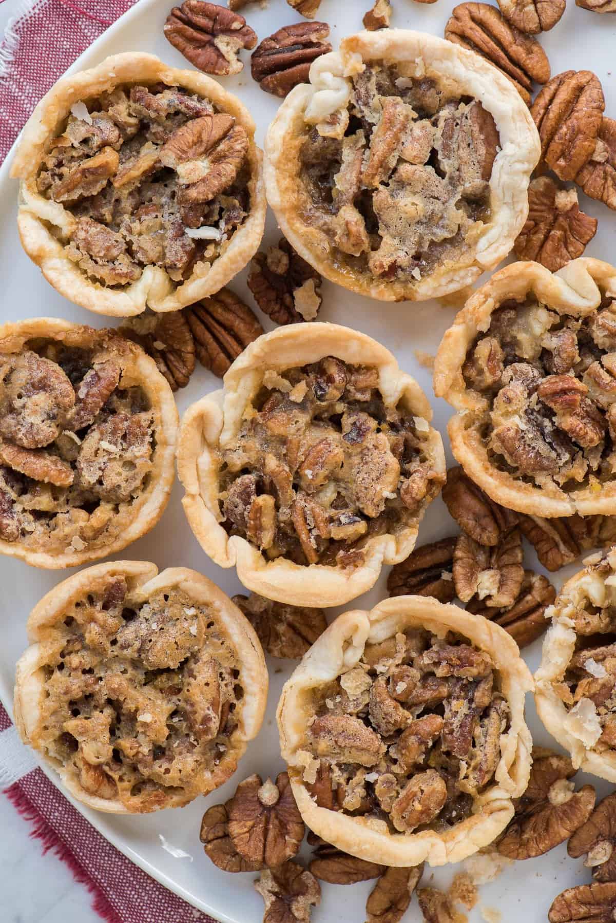 aerial shot of 8 mini pecan pies on white tray with red linen 