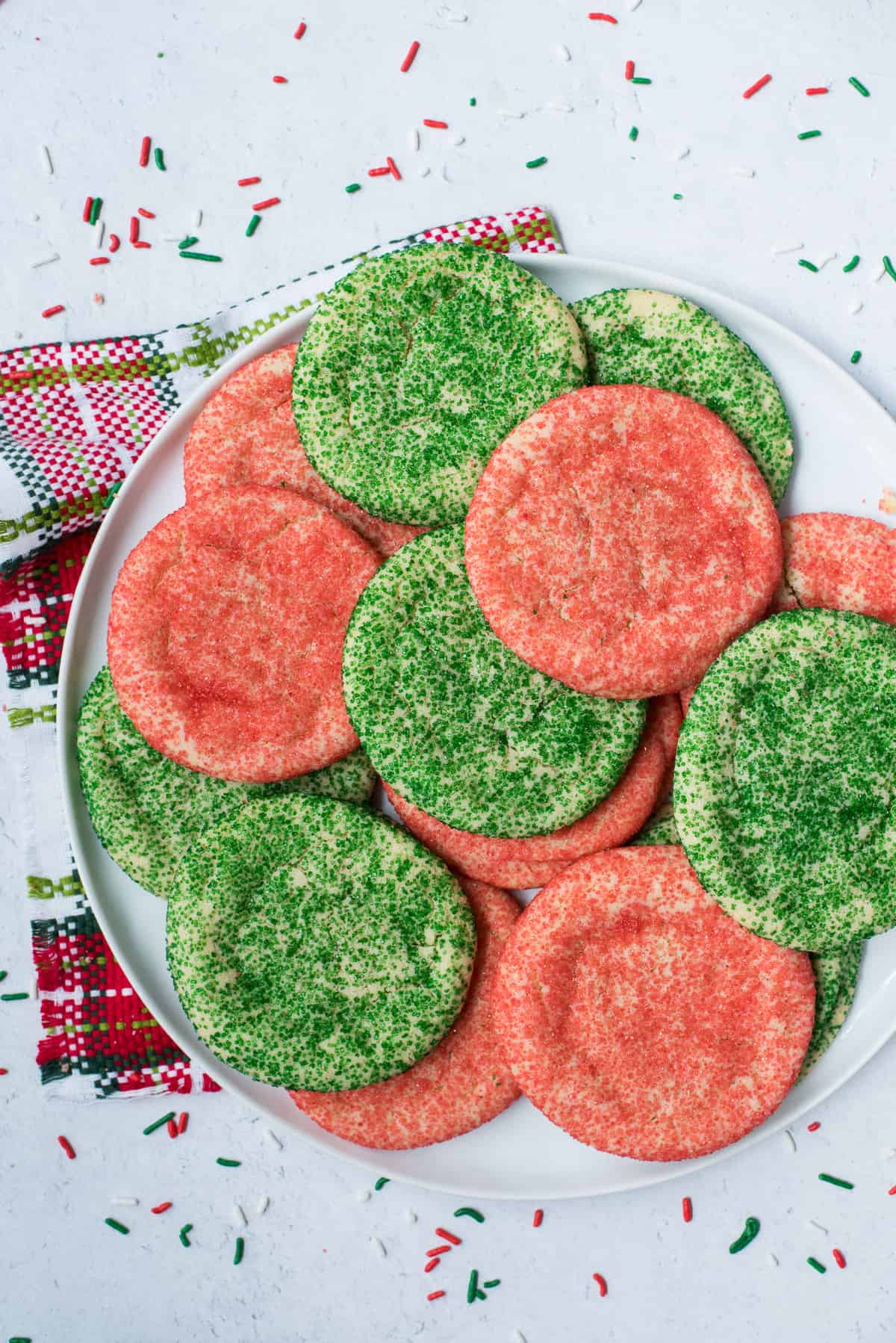 red and green christmas cookies arranged on white tray with Christmas napkin underneath