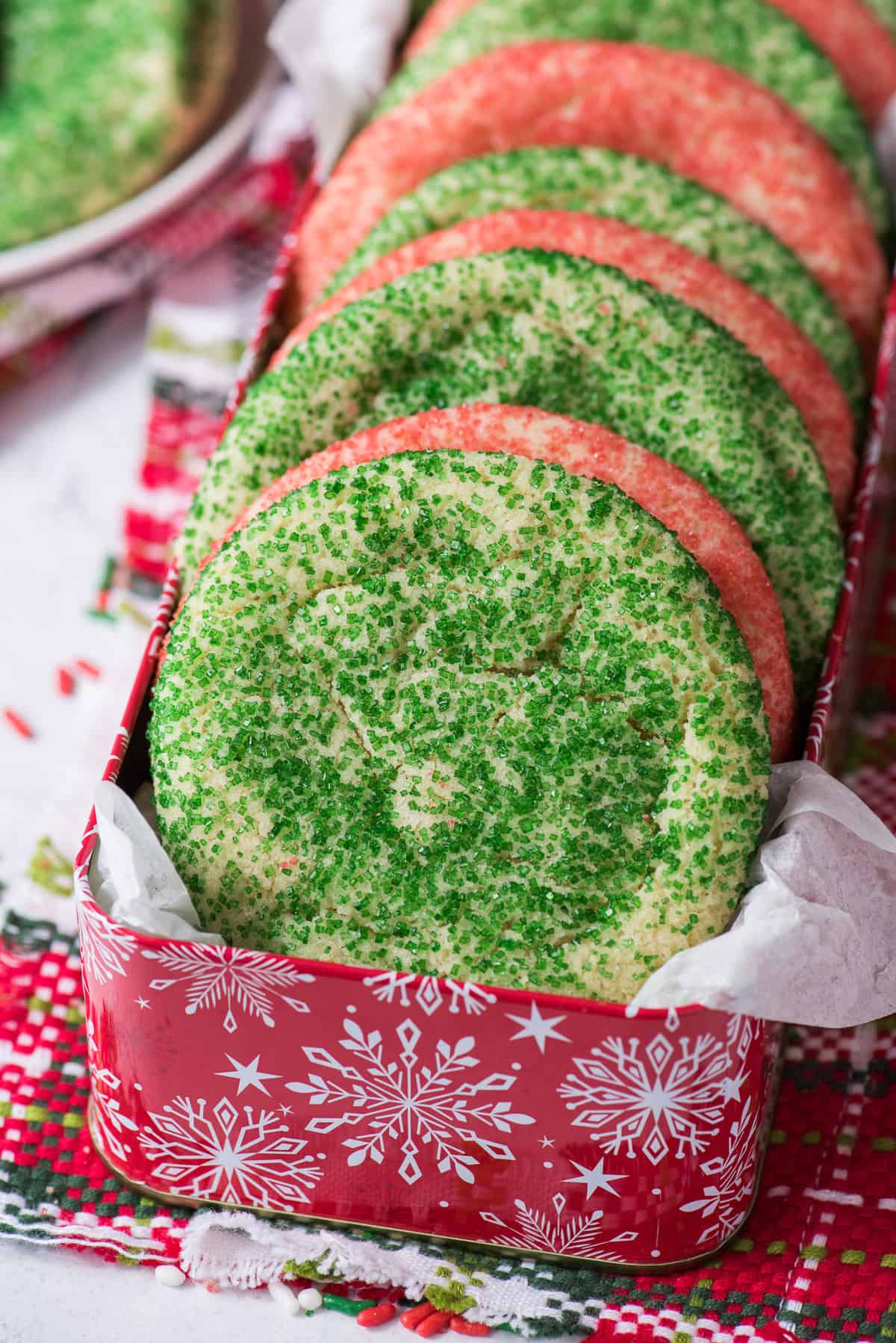 green and red sugar cookies arranged in red Christmas cookie tin