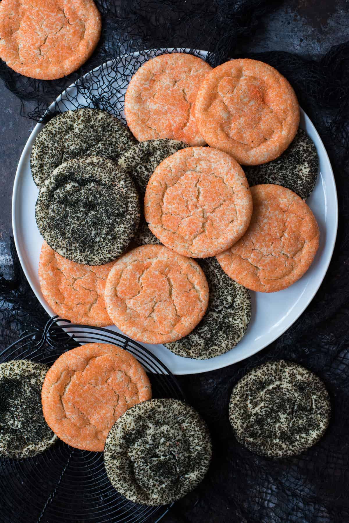 black and orange sugar cookies on white plate on black background