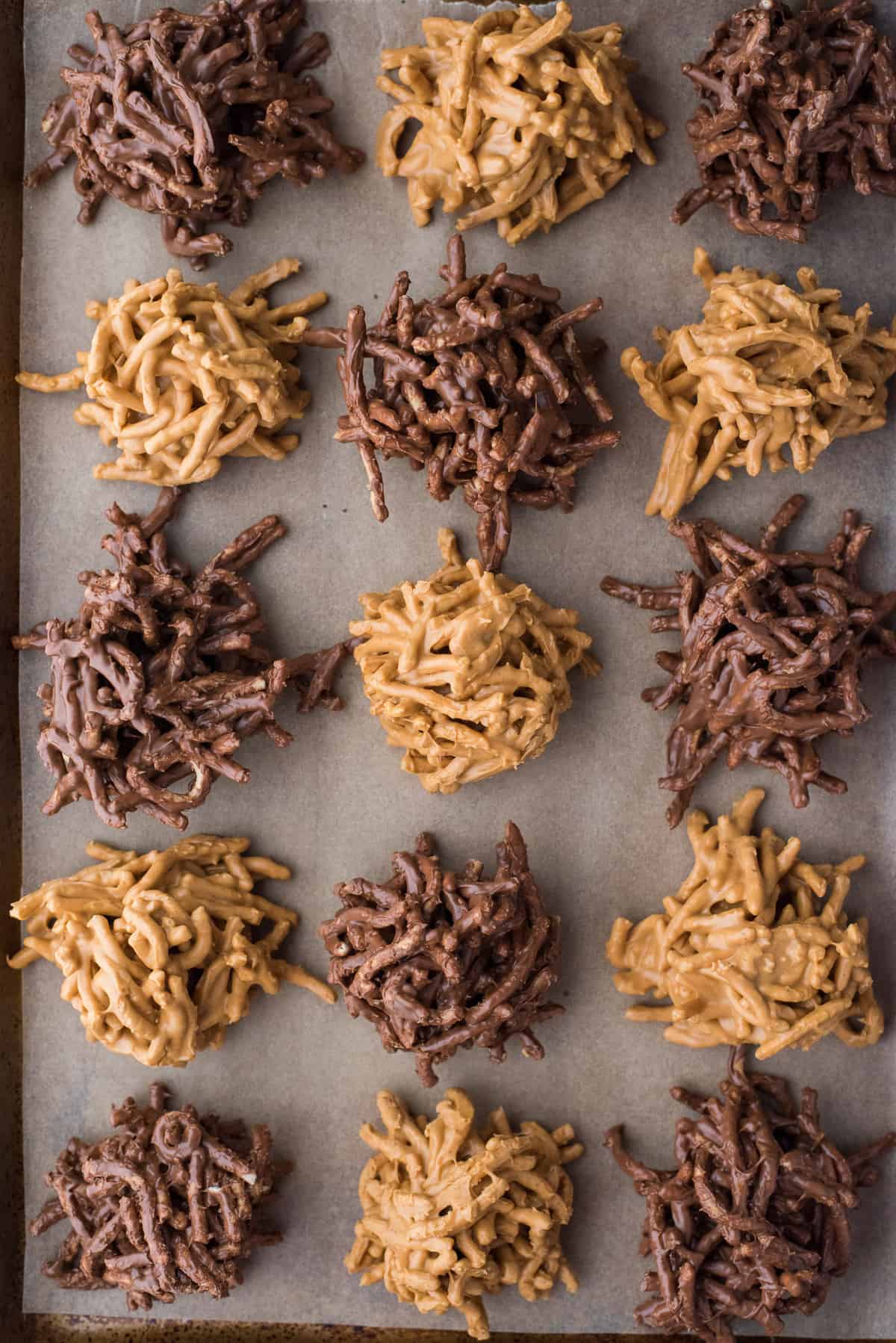 butterscotch haystack cookies and chocolate haystack cookies arranged on brown parchment paper
