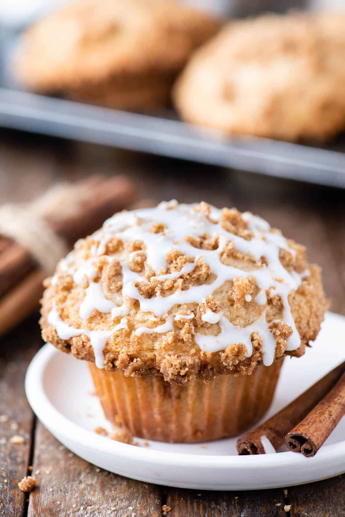 coffee cake muffin with powdered sugar glaze on white plate