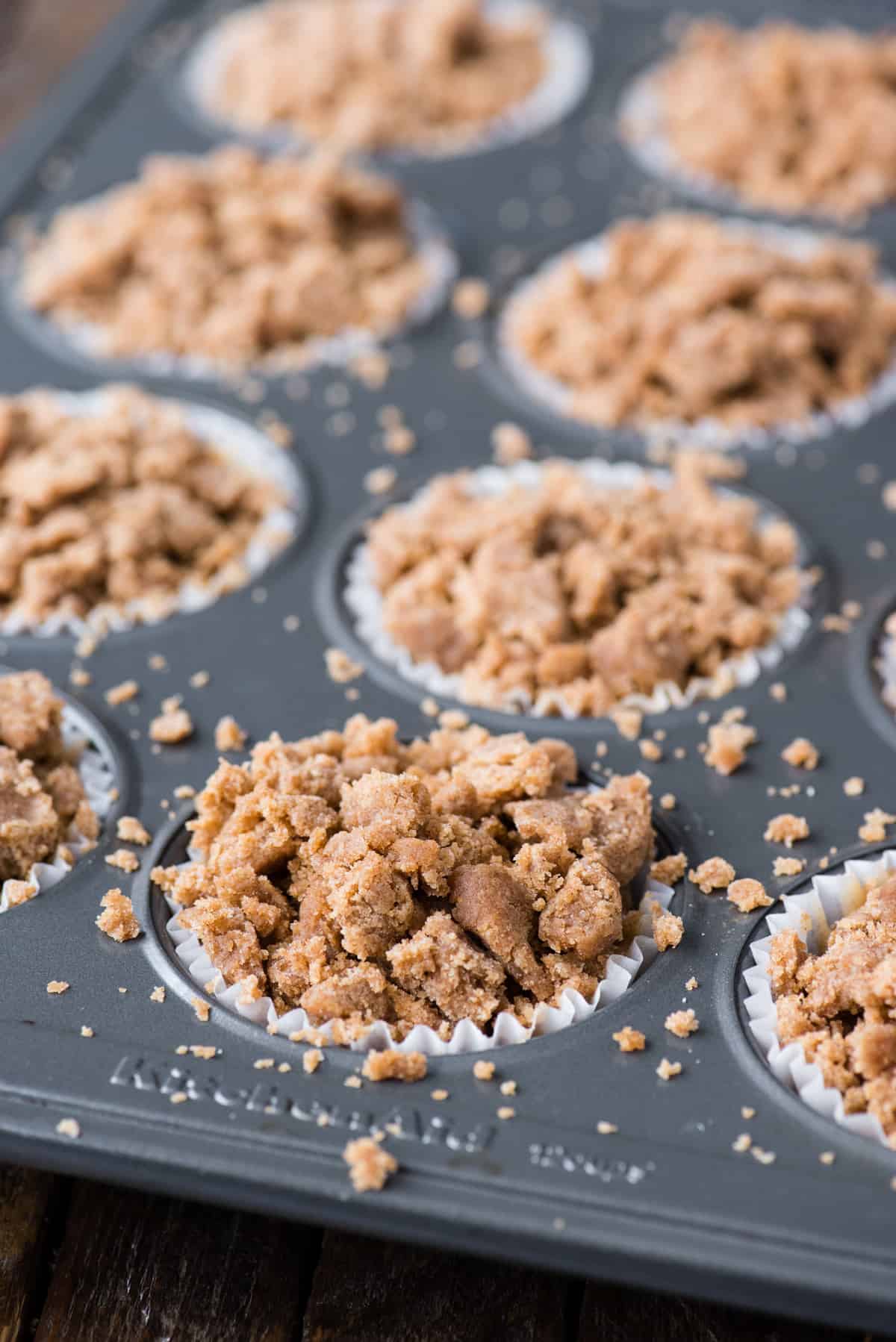 coffee cake muffins with brown sugar crumb topping in metal muffin pan