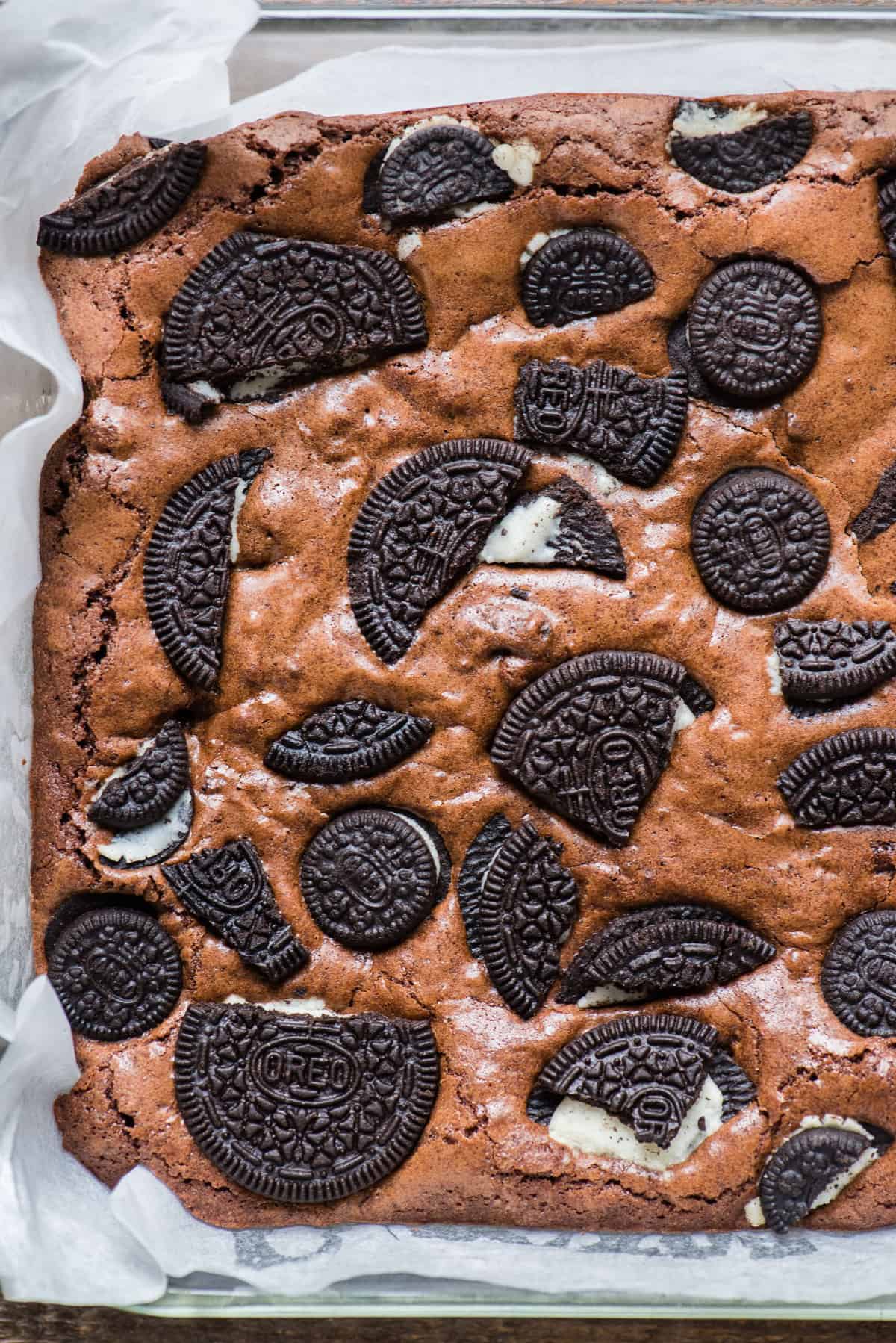 whole pan of oreo brownies in glass dish with white parchment paper