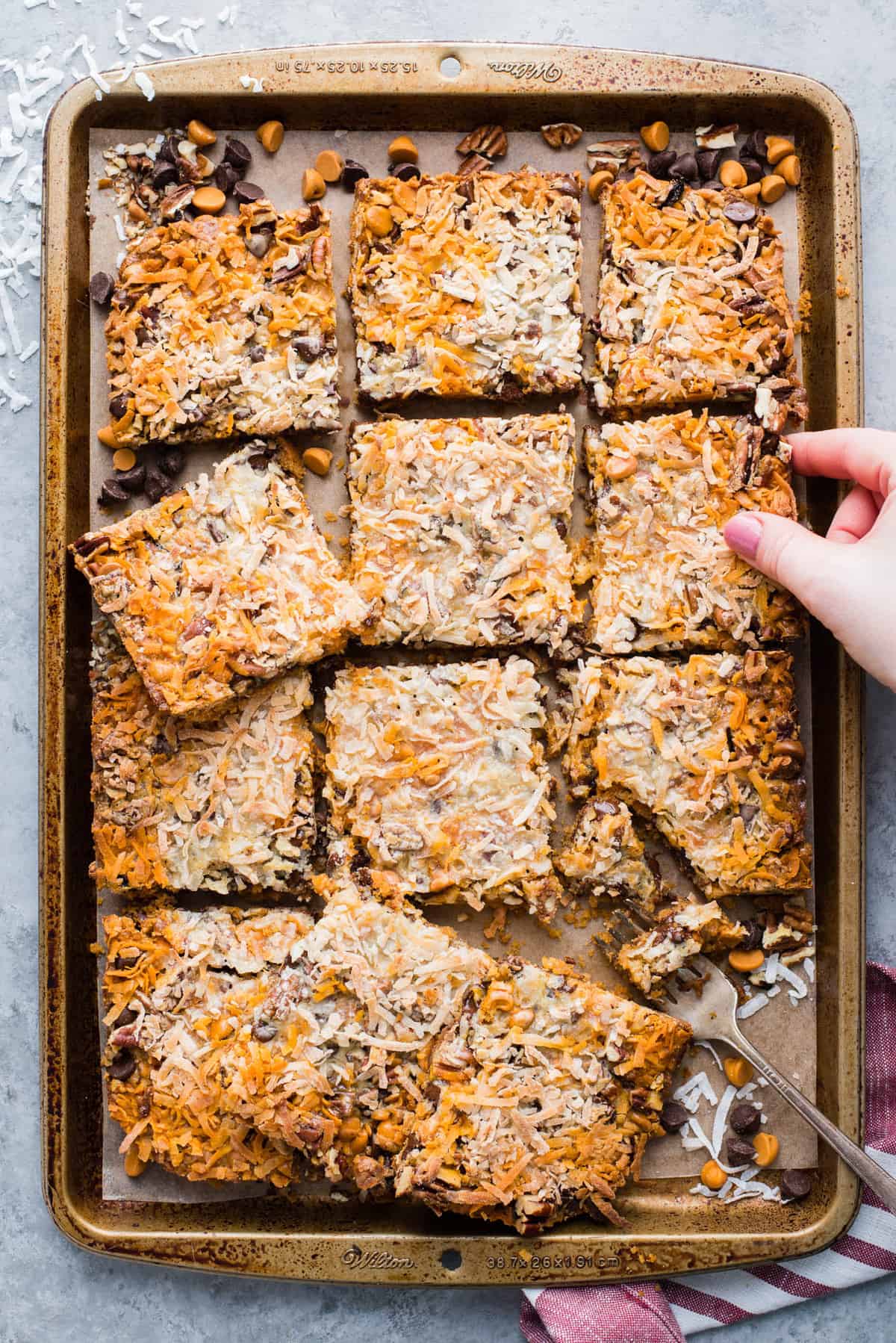 hello dolly bars cut into squares and arranged on a metal baking sheet