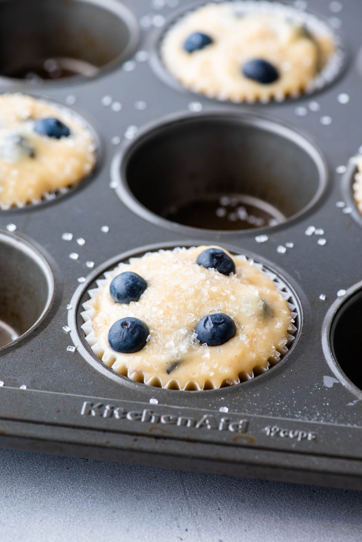 close up of blueberry muffin batter in muffin pan