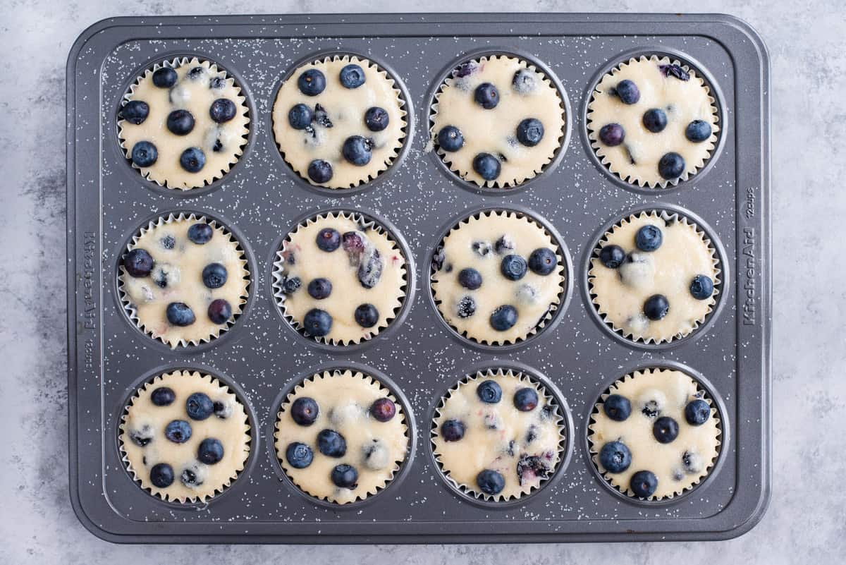 blueberry muffin batter in metal muffin pan