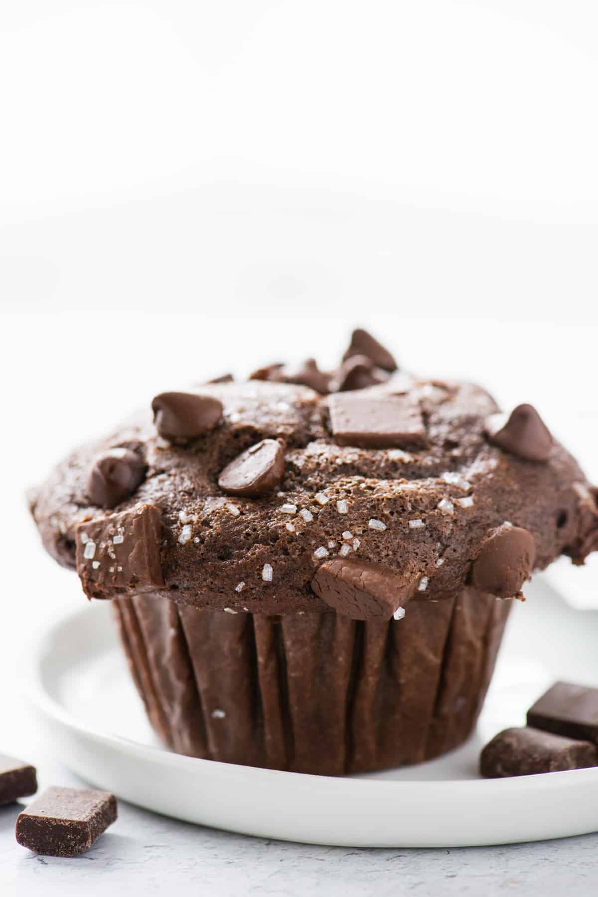 double chocolate chip muffin on white plate on white background