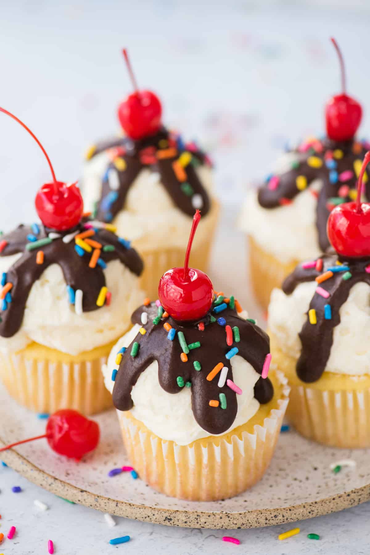 ice cream cupcakes displayed on white speckled plate on white background