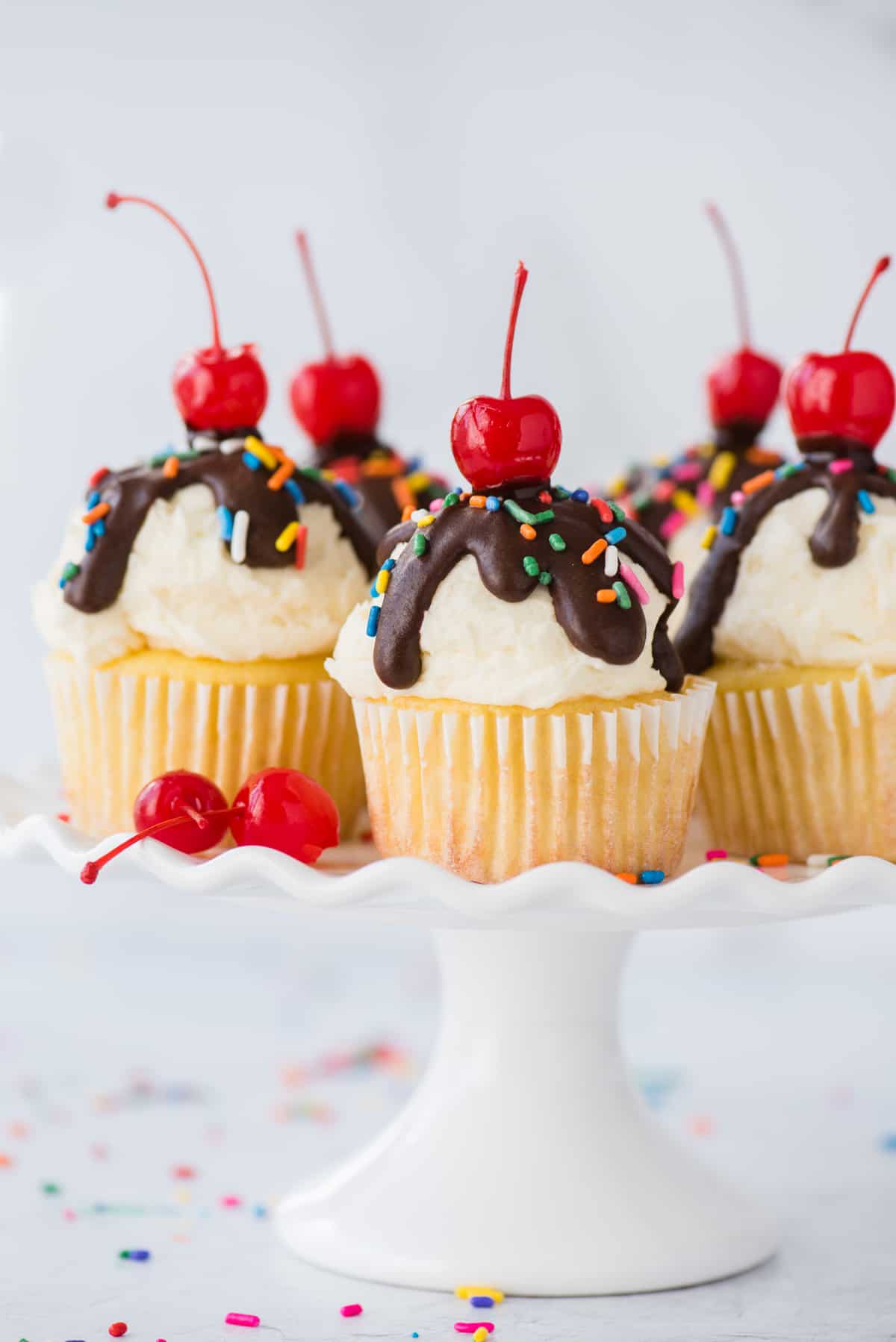 ice cream cupcakes displayed on white cake stand on white background