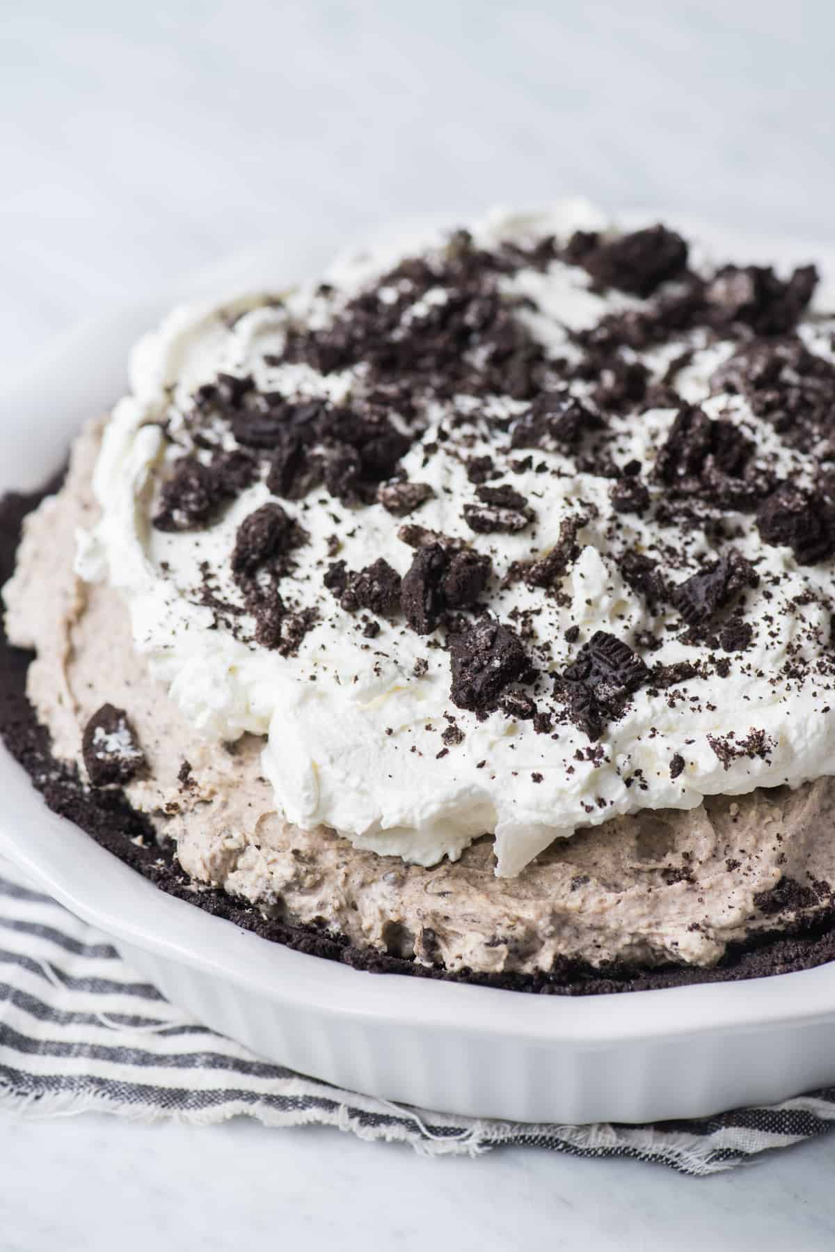 whole no bake oreo pie with whipped cream topping and crushed oreos on top