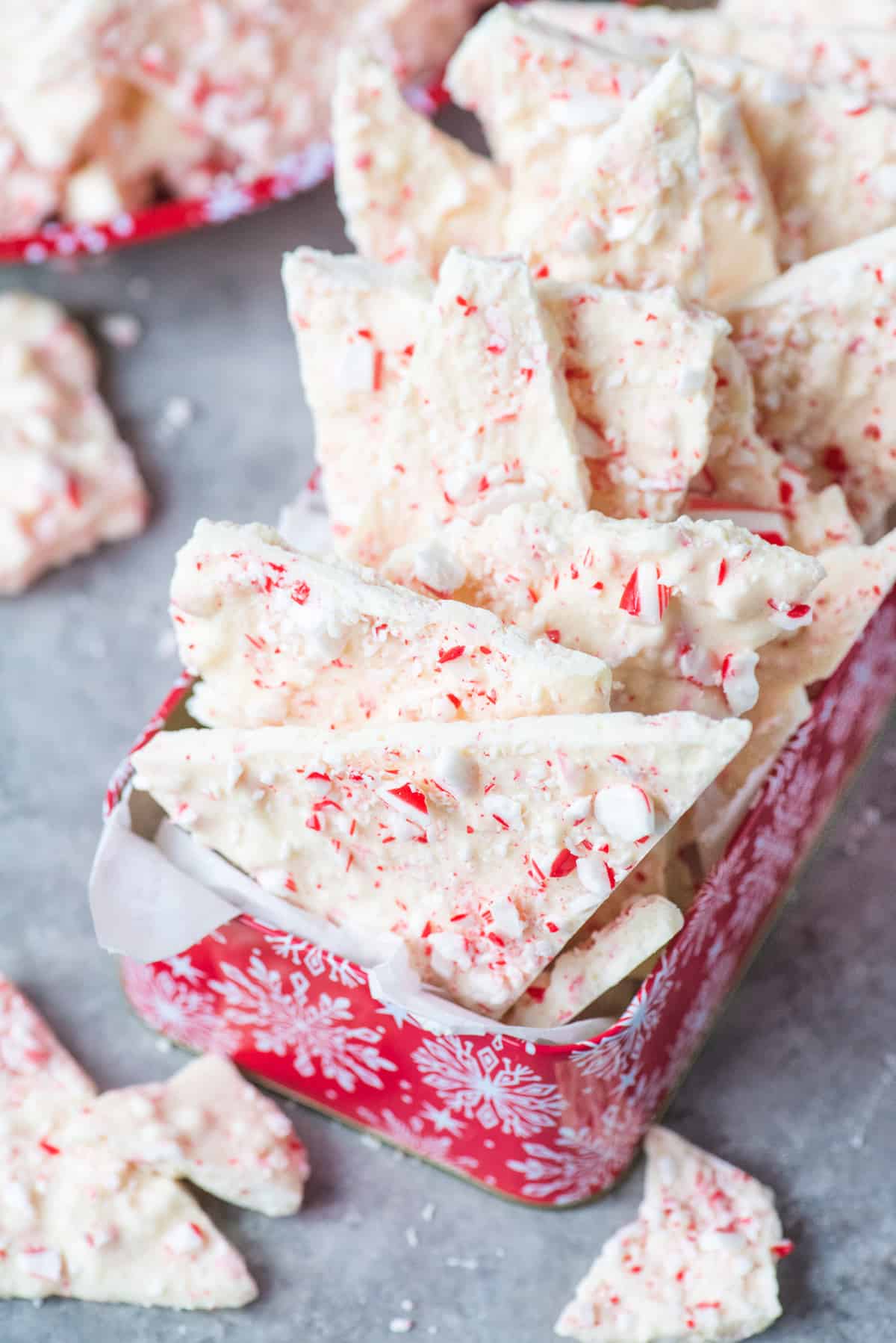 white chocolate peppermint bark arranged in red christmas tin