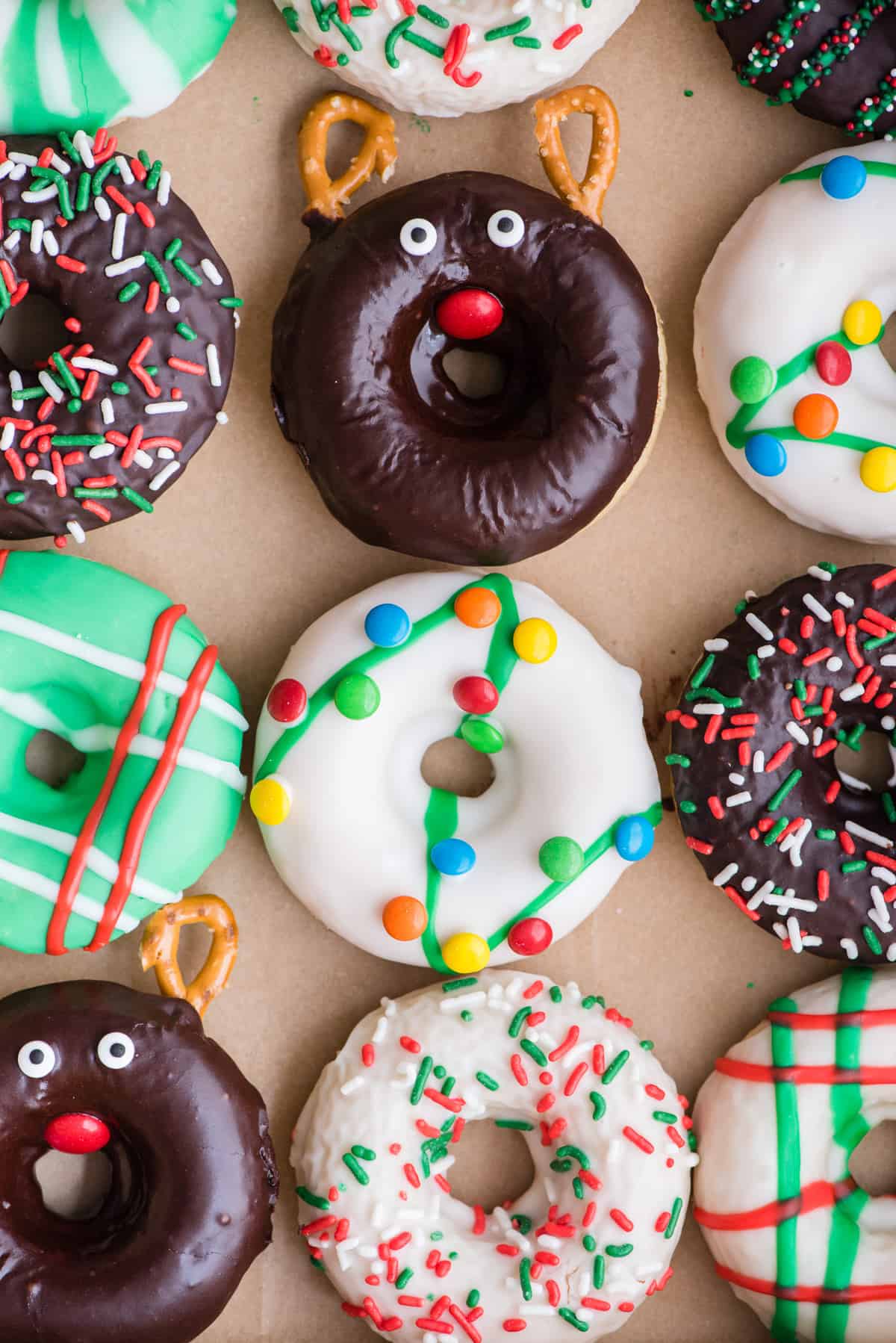 12 christmas donuts arranged in a grid in a donut box