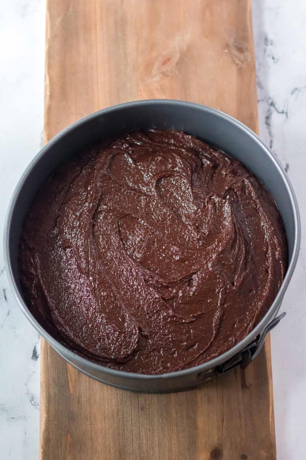 brownie batter in a circle cake pan