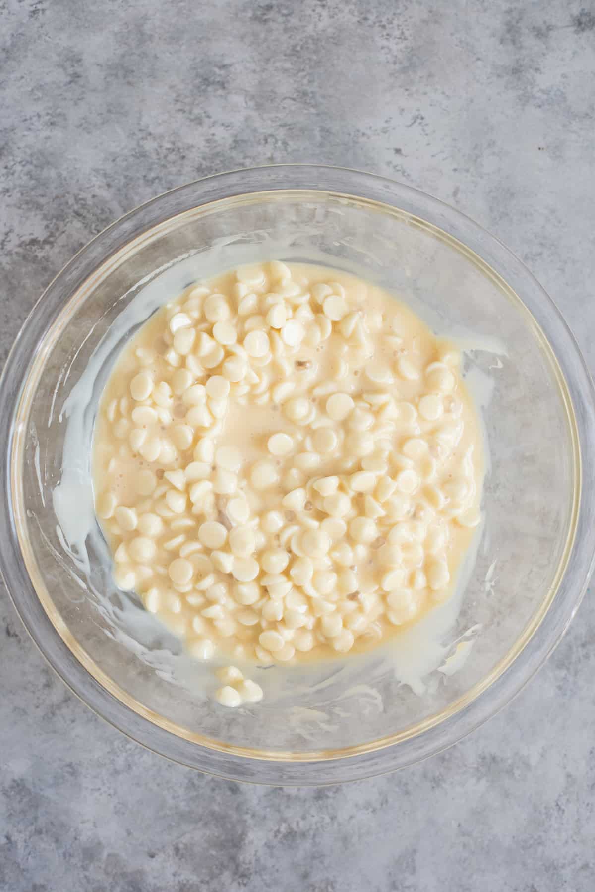 glass bowl with white chocolate chips and sweetened condensed milk