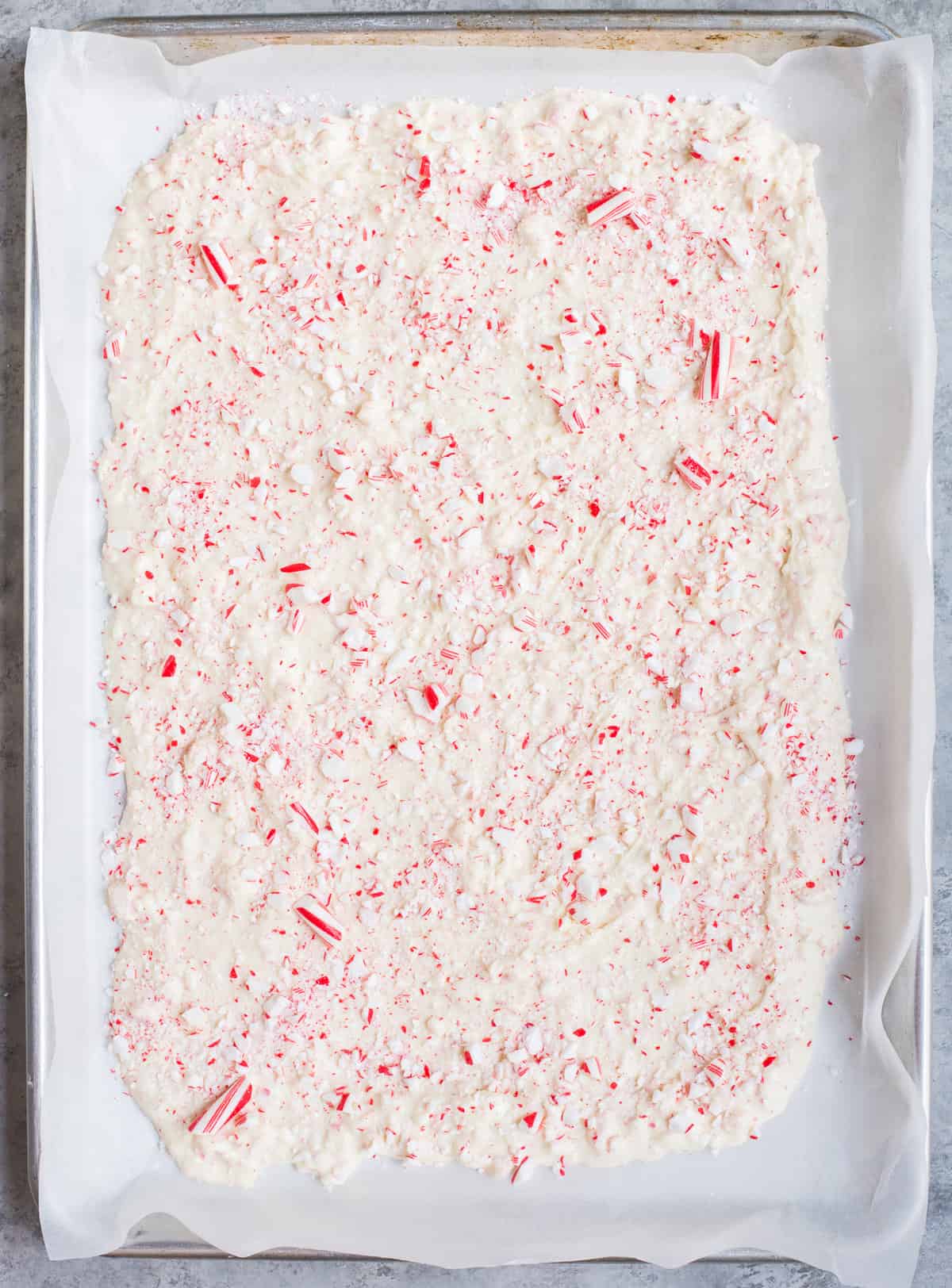 white chocolate peppermint bark spread into even layer on parchment paper