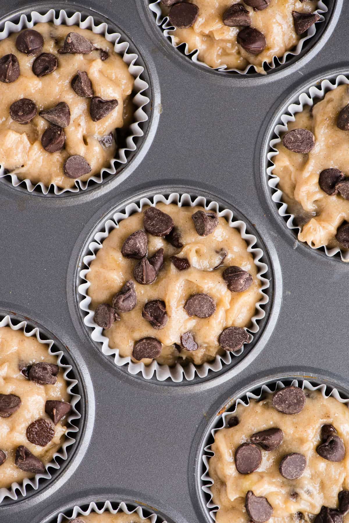 gluten free banana muffin batter with chocolate chips in metal muffin pan
