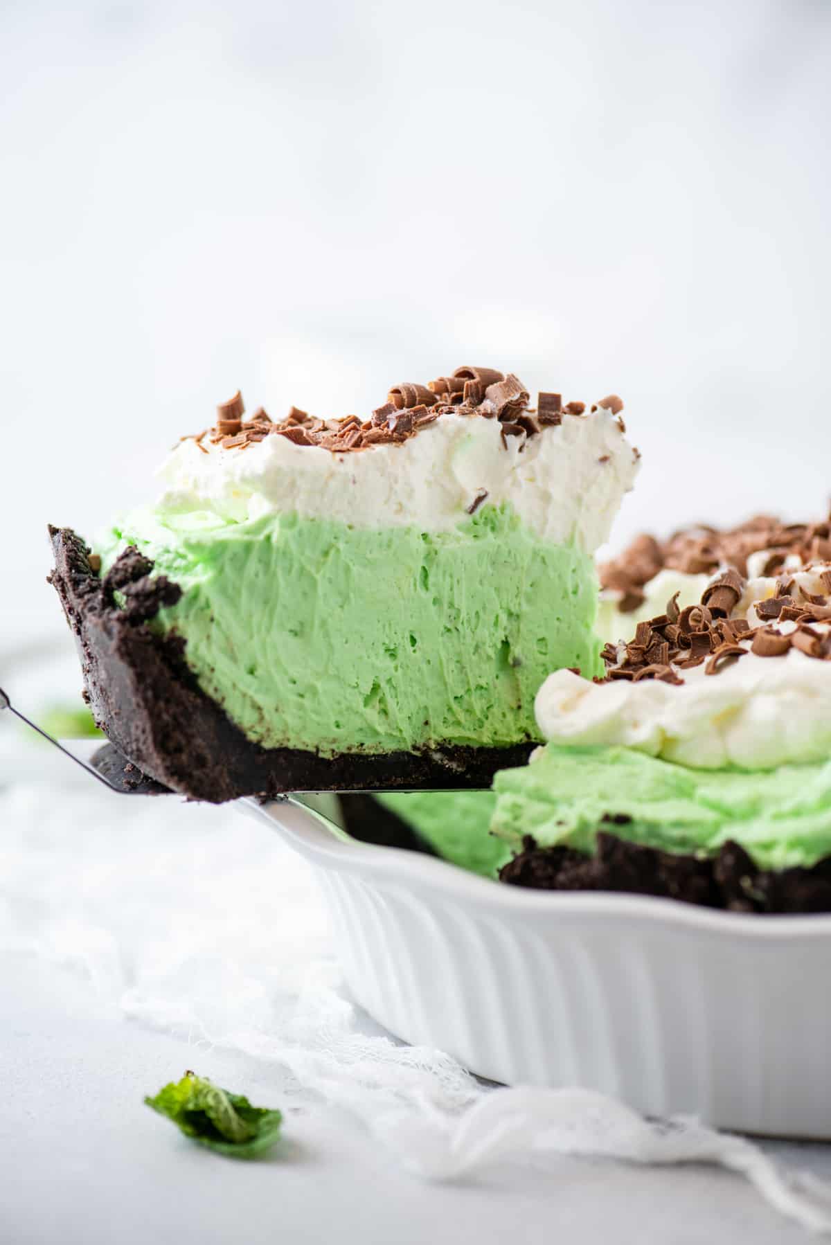 slice of grasshopper pie being removed from white pie pan