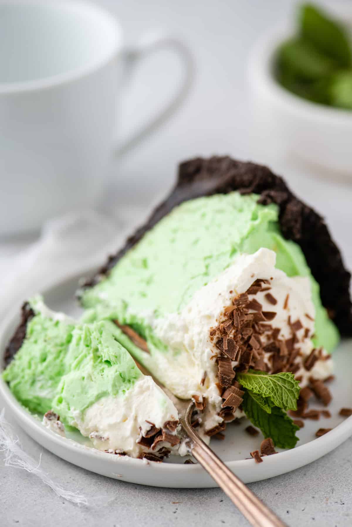 slice of green mint pie on white plate on white background