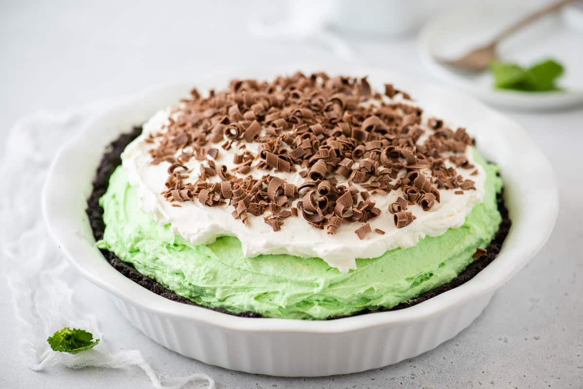 grasshopper pie with chocolate curls in white pie pan on white background