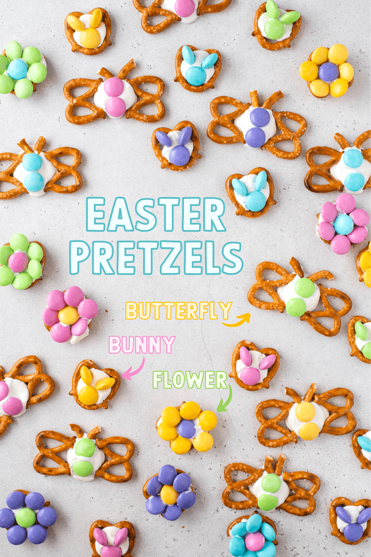 butterflies, bunnies and flowers made from pretzels, candy melts and m&ms arranged on gray background with text overlay