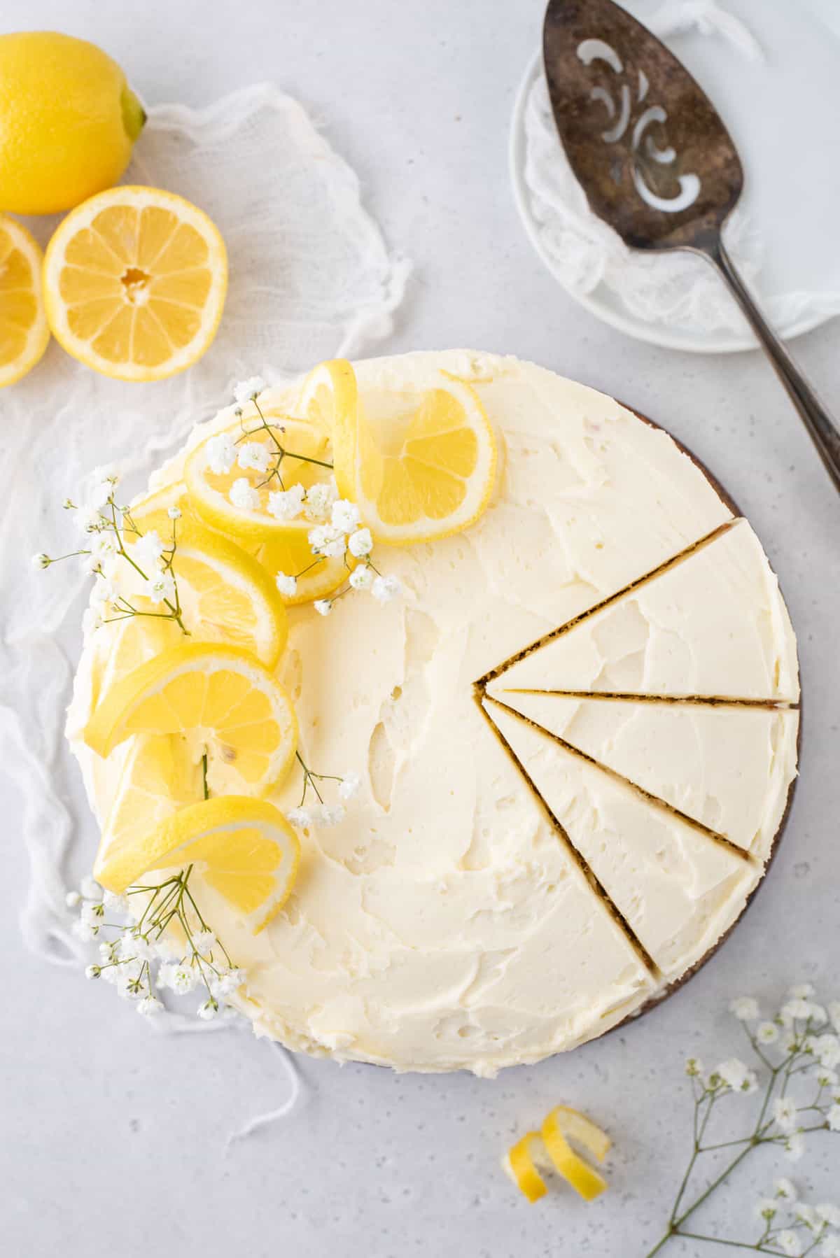 Overhead view of round lemon layer cake, with 3 slices cut