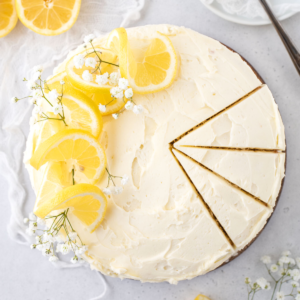 Overhead view of round lemon cake with three slices cut