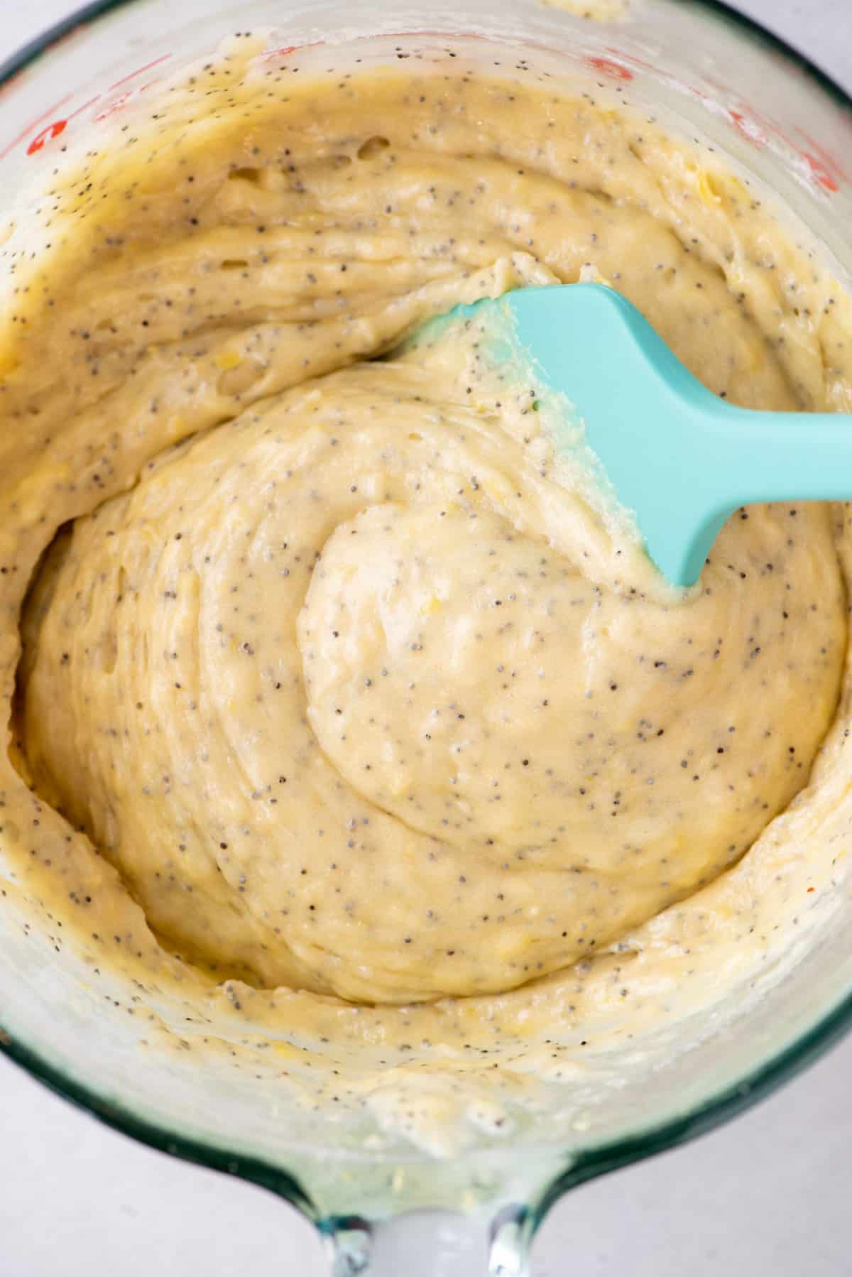 Lemon poppy seed batter in mixing bowl with rubber spatula
