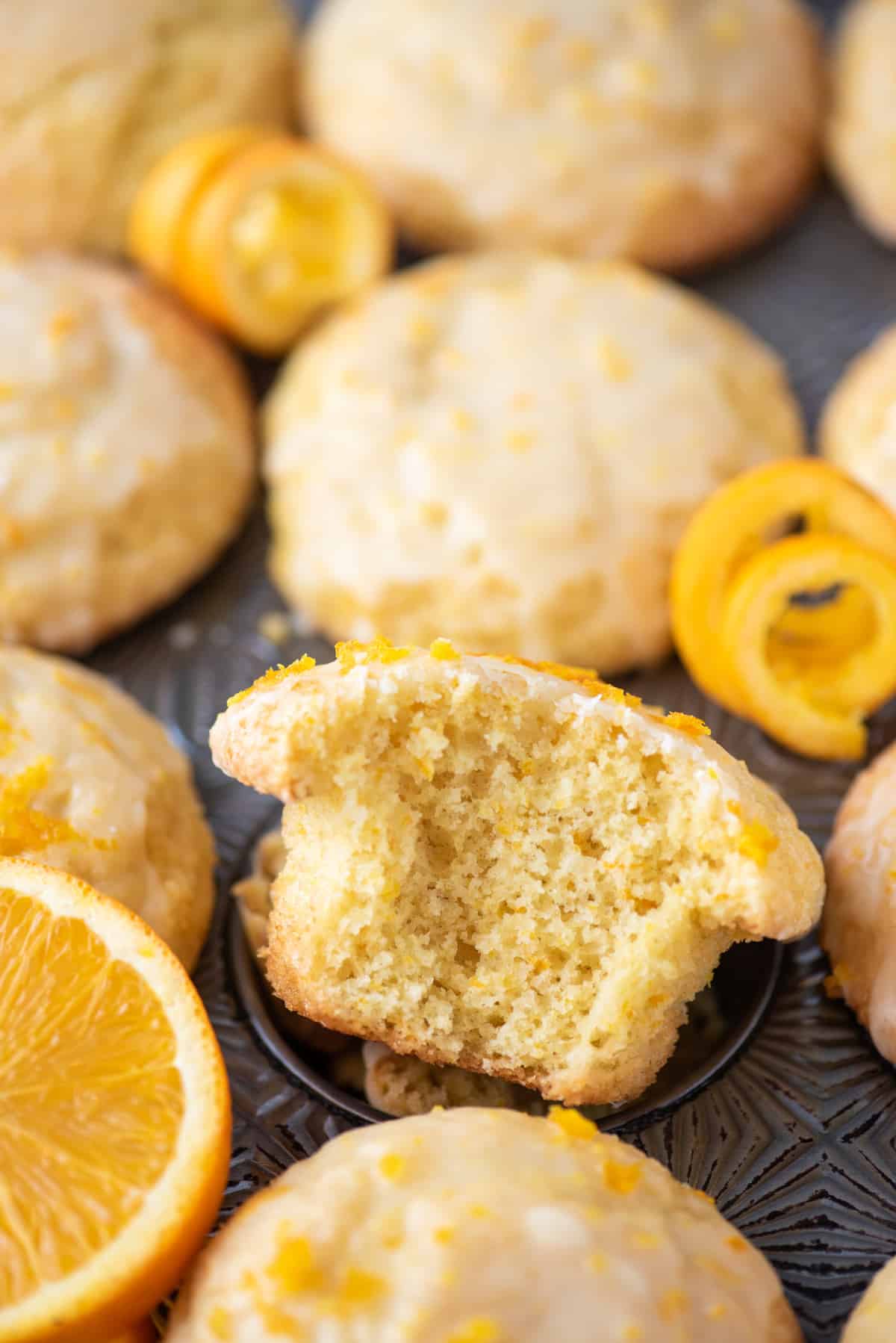 bite removed from orange muffin in metal muffin pan
