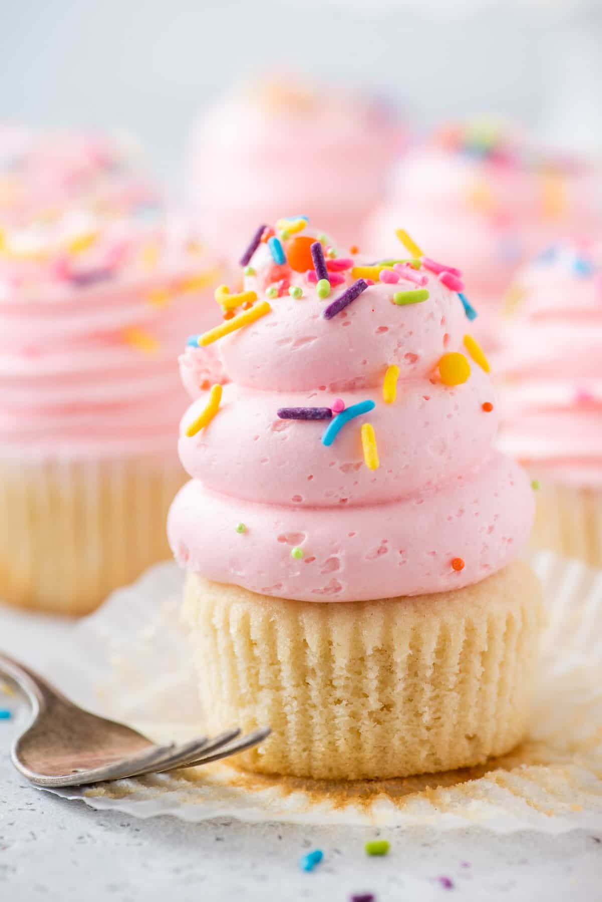 Gluten-free cupcake topped with pink vanilla buttercream and sprinkles