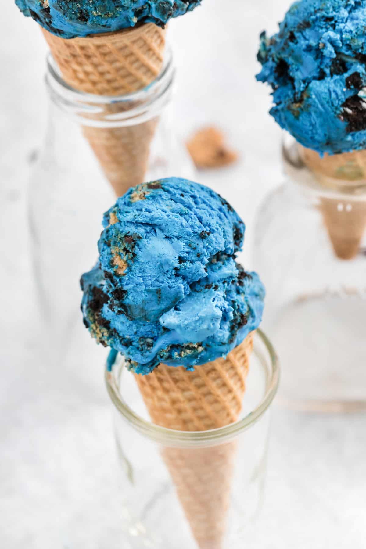 Three jars holding cones of Cookie Monster Ice Cream