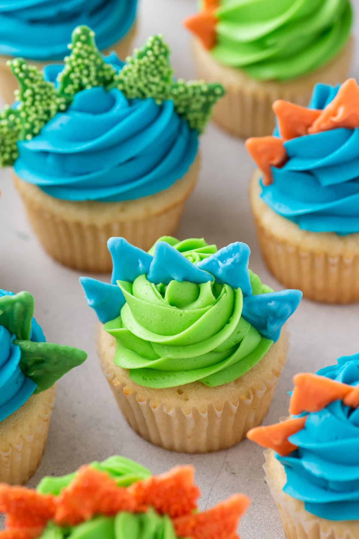 Dinosaur cupcakes with colored frosting and spikes