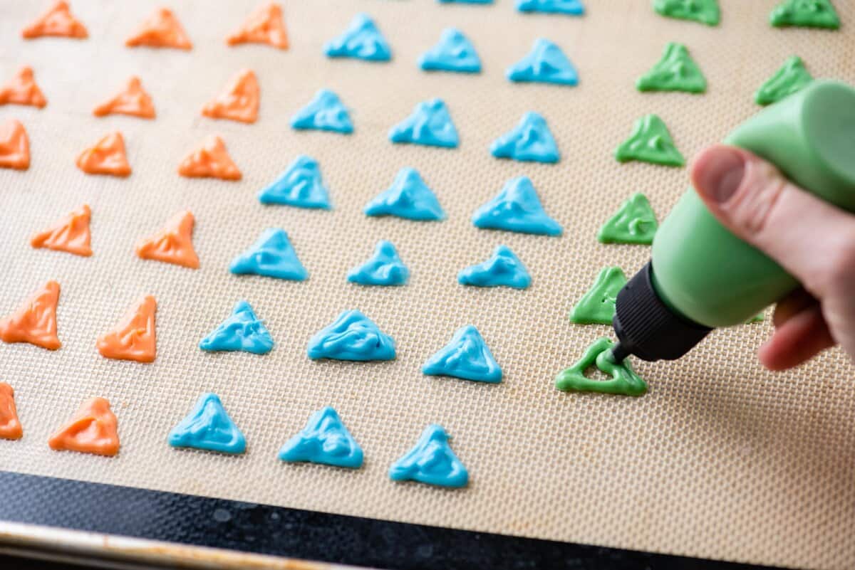 Piping colored almond bark into the shape of dinosaur spikes