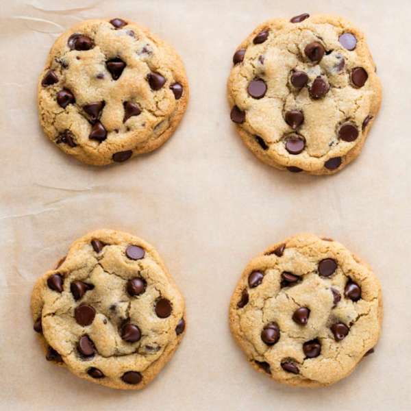 Overhead view of 4 chocolate chip cookies on parchment paper