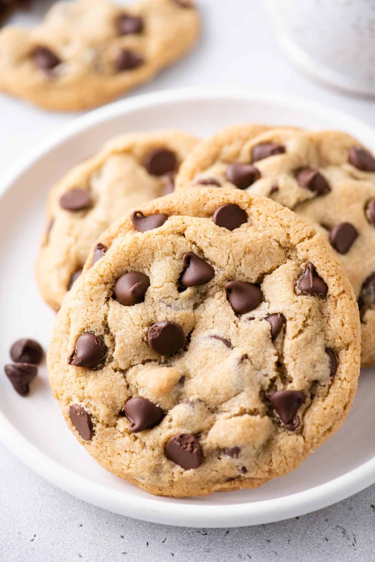 3 chewy chocolate chip cookies on a white plate