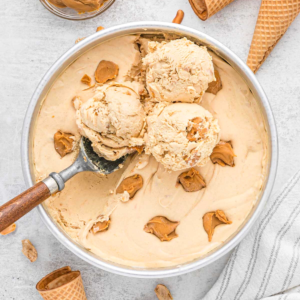 Round cake pan of peanut butter ice cream with 3 scoops on top
