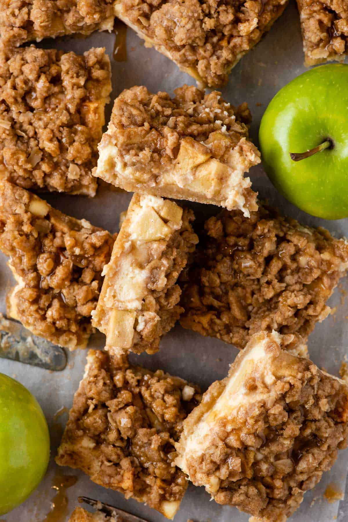 Overhead view of caramel apple cheesecake bars and green apples