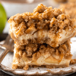 Closeup of stacked caramel apple cheesecake bars with bite taken out of top bar