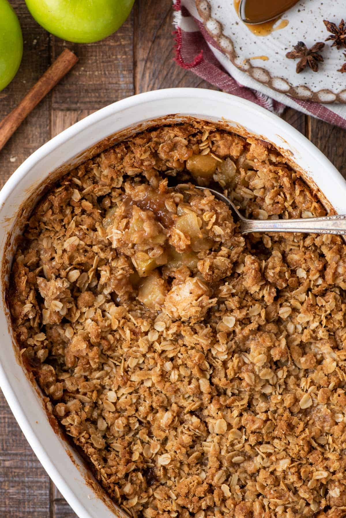 Overhead view of caramel apple crisp in baking dish with spoon
