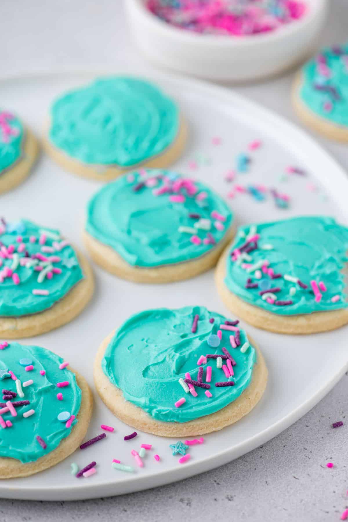 Round gluten-free sugar cookies with aqua frosting and sprinkles