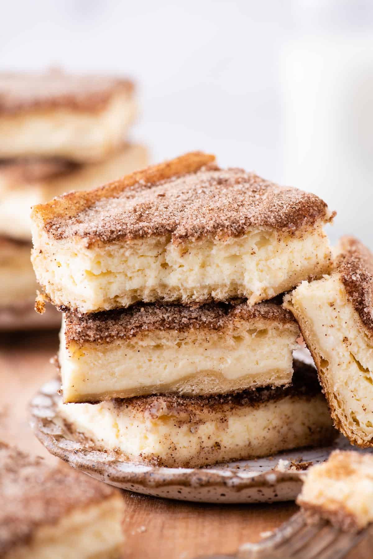 Three churro cheesecake bars stacked on each other