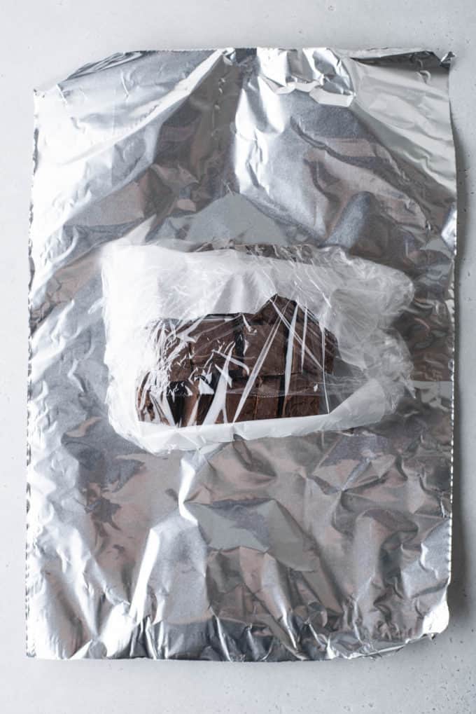 chocolate fudge wrapped in plastic wrap on top of aluminum foil 